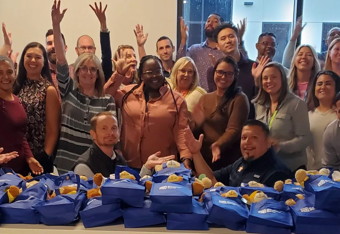 Corporate group celebrating after assembling bears for children